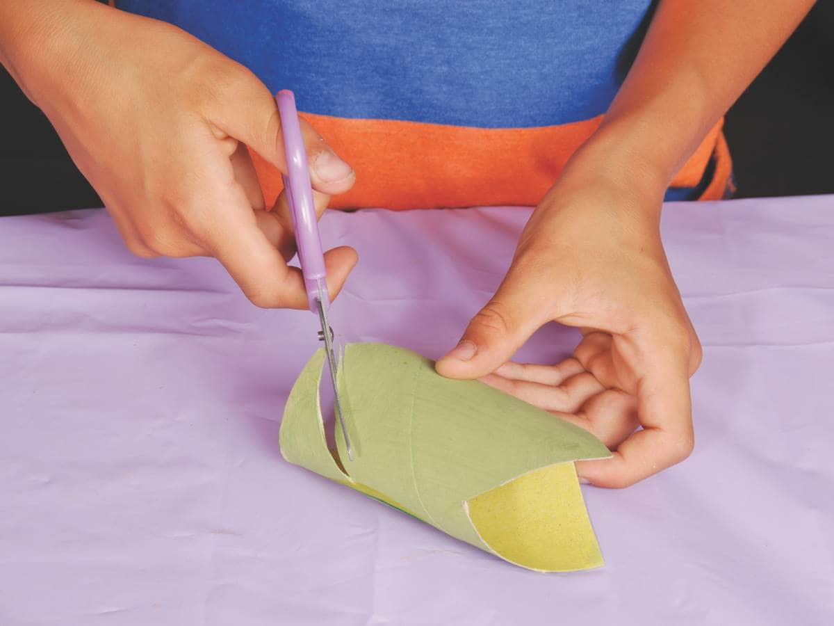 an adult cutting the head of the craft snake