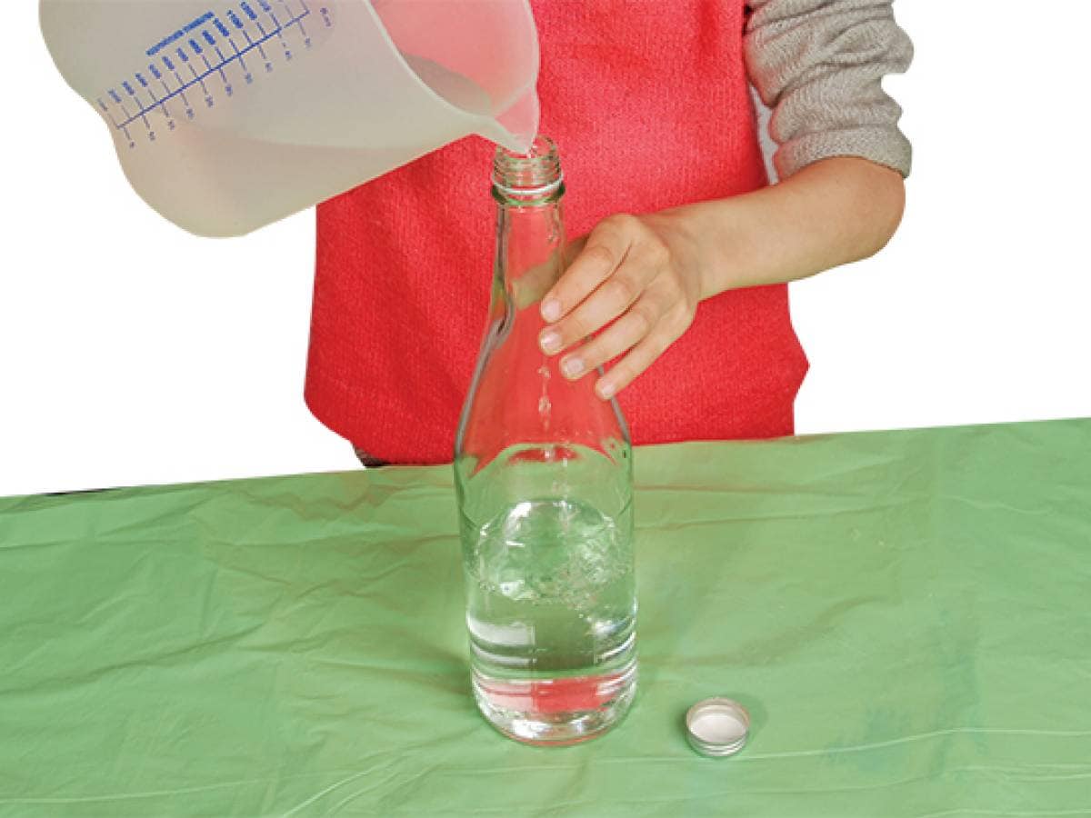 Person pouring water into a bottle