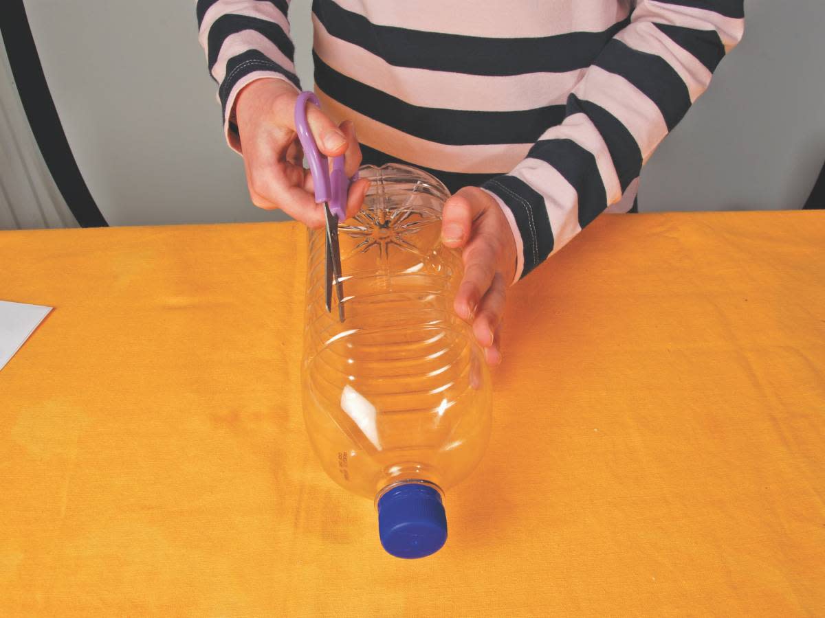 Person cutting up plastic bottle