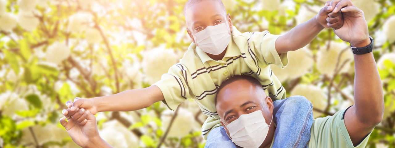 Dad and son on shoulders wearing face masks