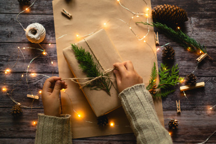Person wrapping a present in brown paper