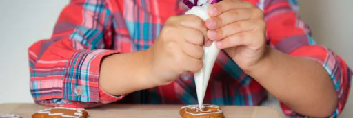 A child icing homemade biscuits.