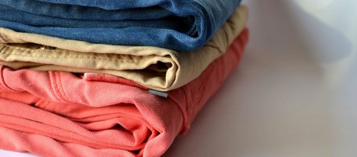 A pile of folded jeans in different colours.