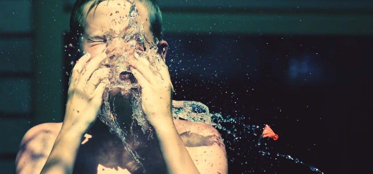 A child with water on his face.