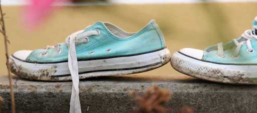 A pair of muddy turquoise trainers.