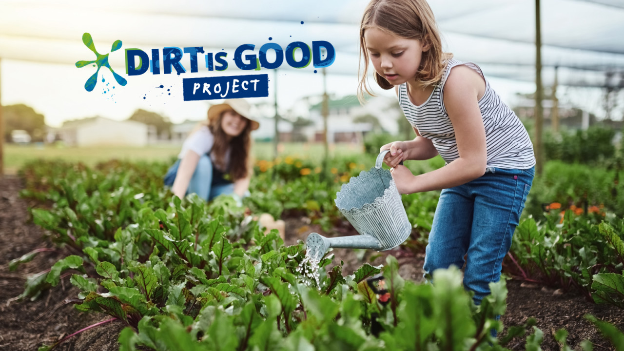 A girl watering plants in a garden with the Dirt is Good Project logo next to her