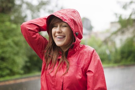 A smiling woman with red rain coat.